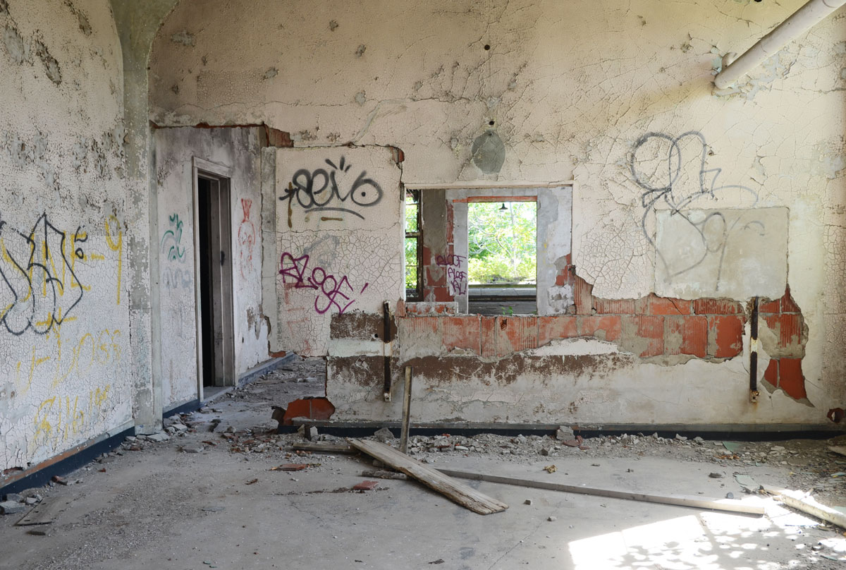 walls in a state of decay and crumbling, with scrawls and graffiti on them 