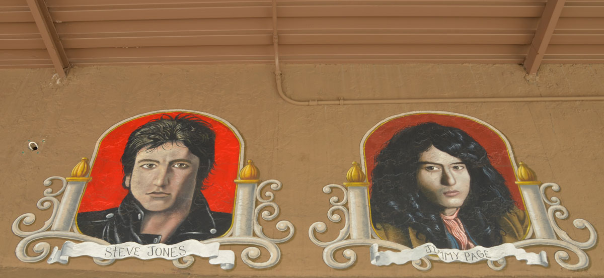 portraits of two guitar players (head shots) on the outside of a guitar store - Steve Jones and Jimmy Page
