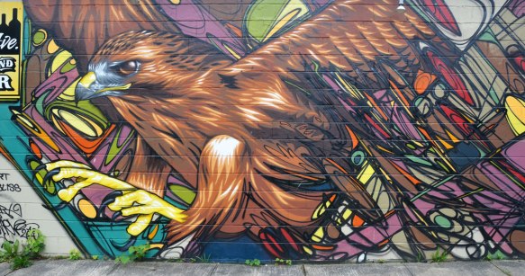 on the side of a building, large eagle taking flight