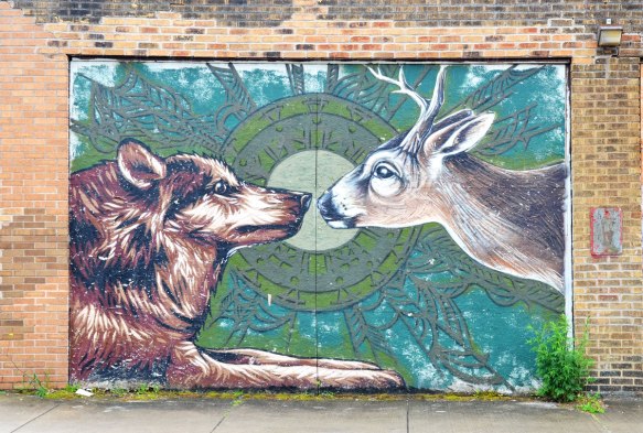 mural on a garage door of a dog and deer meeting nose to nose