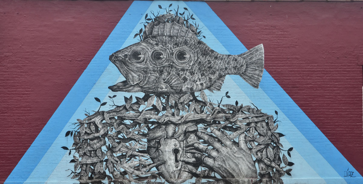 mural in a blue triangle of a person like shape with a three eyed fish as it`s head, upper body made of a tightly woven vine, heart with a keyhole in it, hand