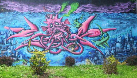 A pink squid like marine creature under the water, but it's tentacles become very tag like 