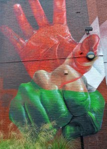 part of a larger mural - two hands, a red open hand and below it a closed green fist