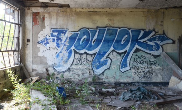 a blue tag that says youlok on a wall in an abandoned building