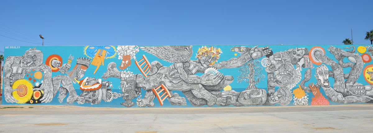 very large horizontal mural that takes up the whole side of one building, with an empty parking lot in front of the mural