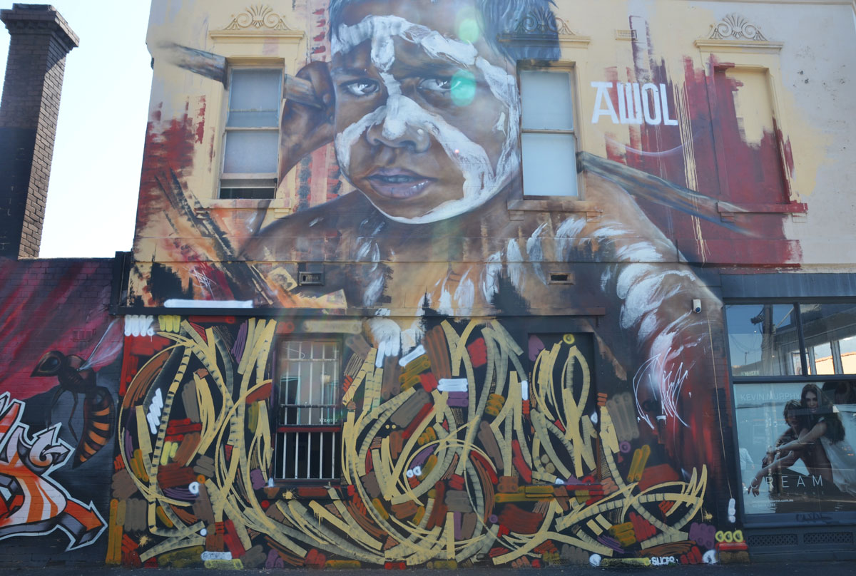 Large mural of the face of an Australian aboriginal boy painted by Adnate in Melbourne, on the side of a two storey building. 