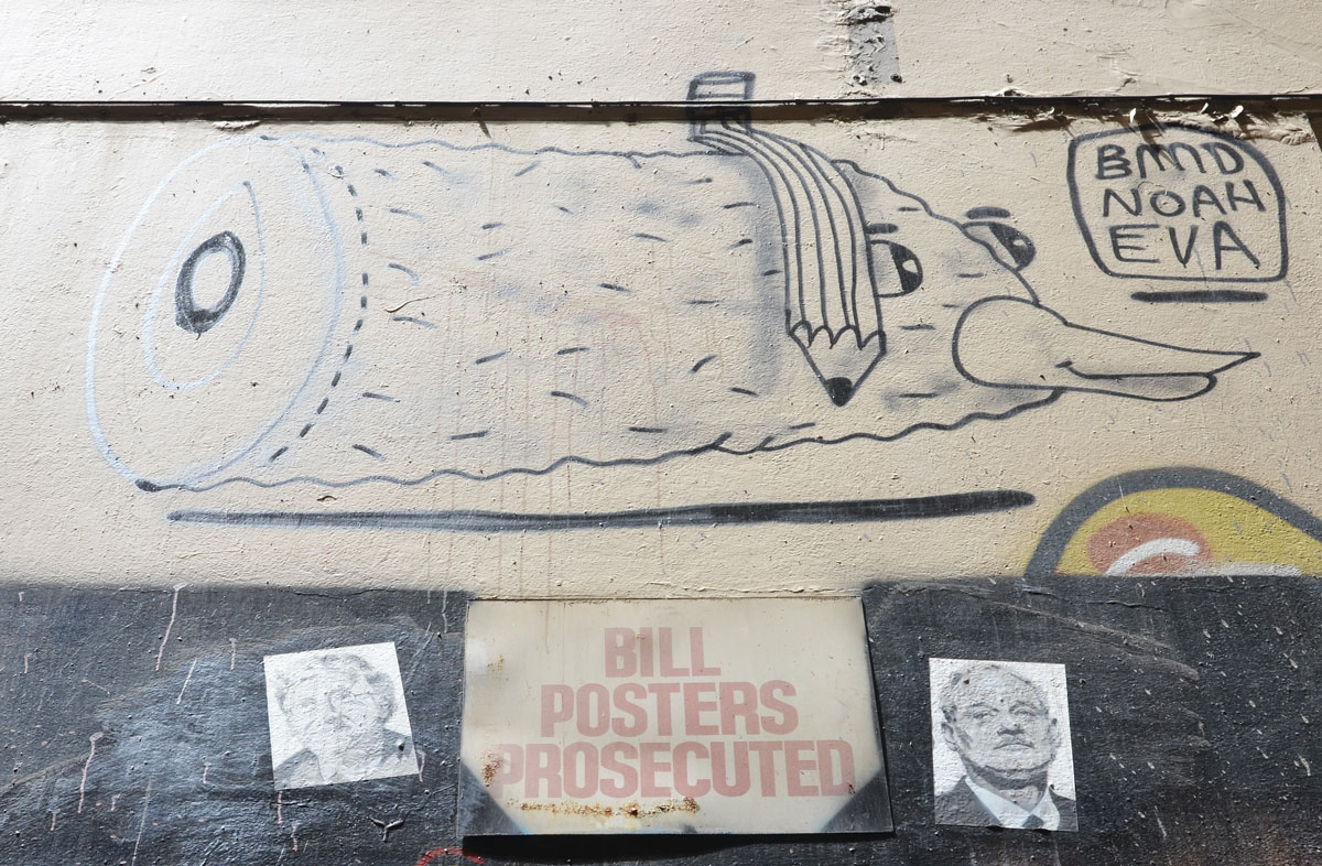The head and neck of a creature with a beak, with a droopy melted pencil lying across it, plus words in a square that say bmd Noah Eva, plus of Bill Murray beside sign that says Bill Posters Prosecuted