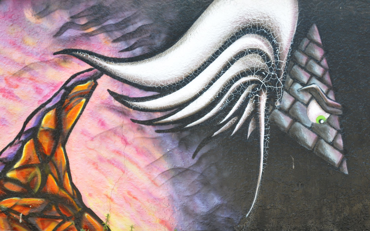 street art creature with triangular face and white mane. 