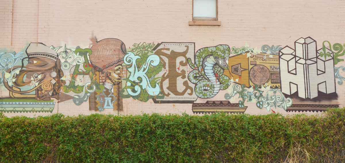 an interesting piece of street art, horizontal across a building, letters, but some animals incorporated into it. K E and S and H for sure but not sure what the other letters are. 
