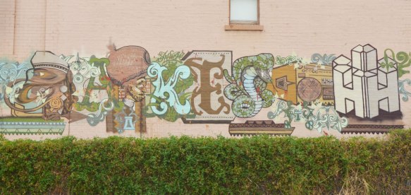 an interesting piece of street art, horizontal across a building, letters, but some animals incorporated into it. K E and S and H for sure but not sure what the other letters are. 