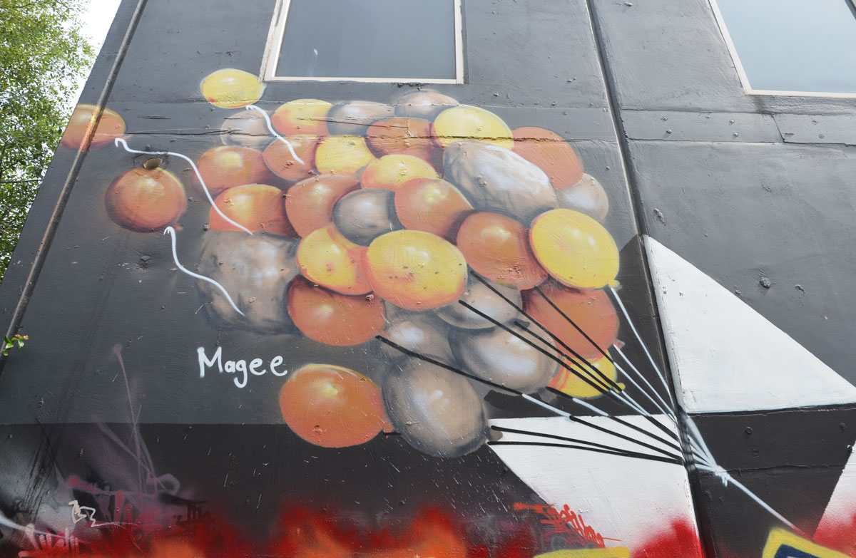 street art of a lot of ballons by Fintan Magee