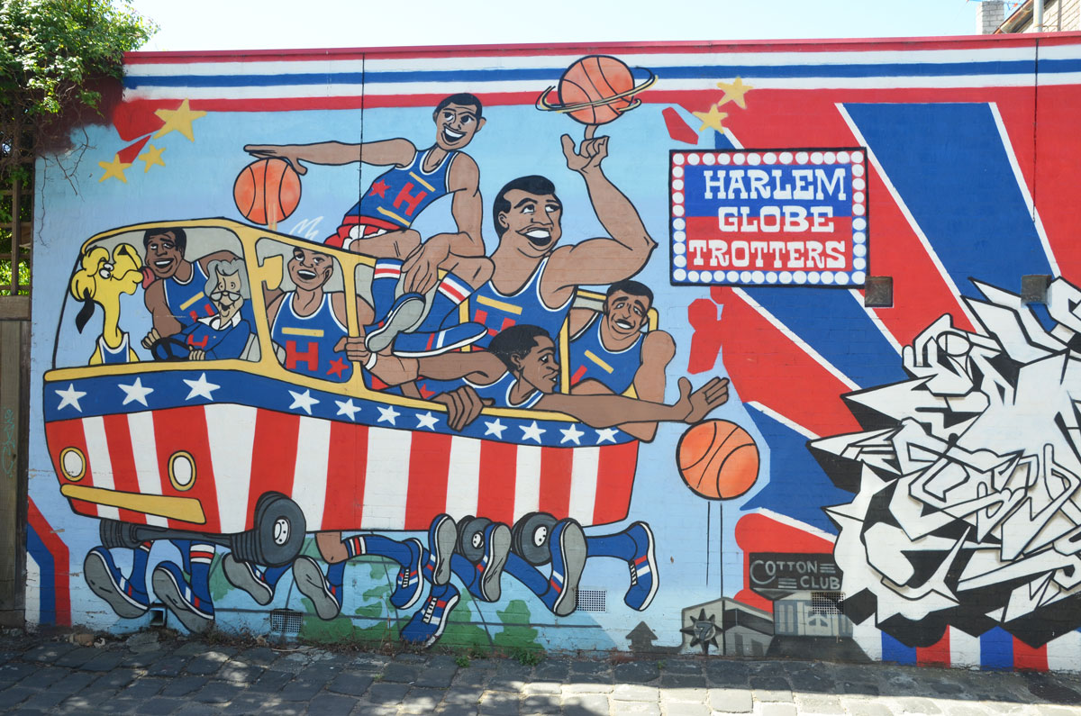 mural of Harlem globetrotters basketball team crowded into a red, white and blue bus. 