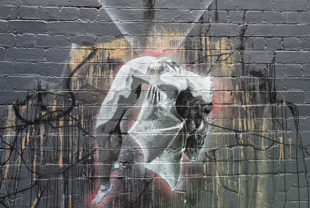 mural on a grey wall of a woman who looks like she's being pulled upward from the waist.