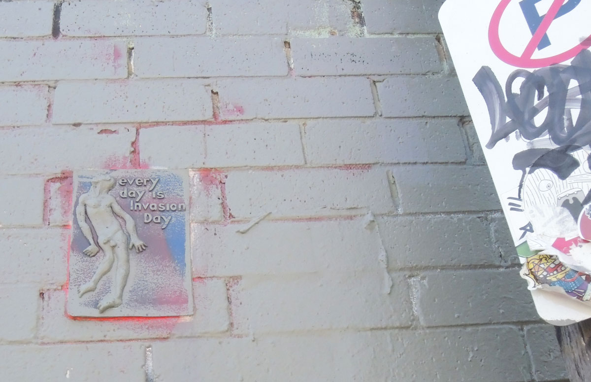 small relief sculpture graffiti of a naked man with the words 'Every day is invasion day'
