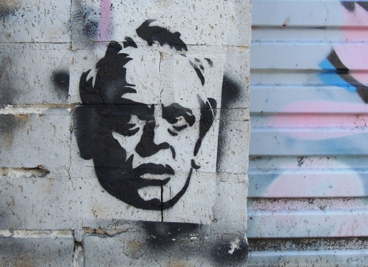 black on white stencil paste-up of a man's head 