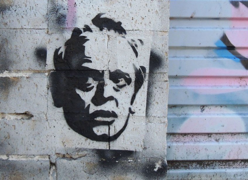 black on white stencil paste-up of a man's head