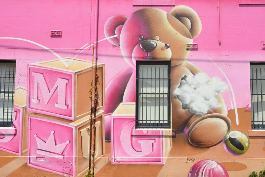 part of a larger mural - a teddy bear sitting behind three wooden blocks