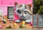 part of larger mural by smug in Melbourne, a kitten with an eye patch, standing in front of a table with marbles on it.