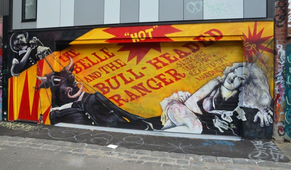 mural with the words (red lettering on yellow), The belle and the bull-headed ranger, along with a picture of a bull