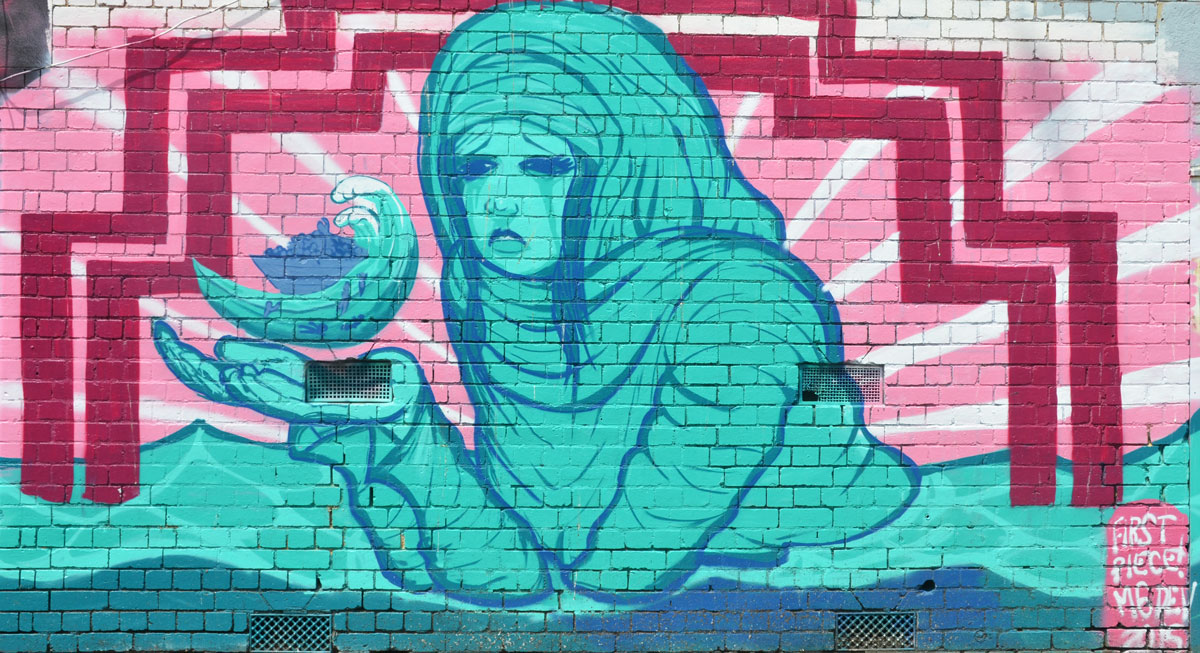 turquoise woman wearing a head scarf and holding on oil lamp. Signed in the corner as first piece Medev. pink border around the woman 