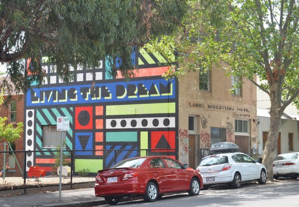 a mural of many geometric shapes on the side of a building, also with the words living the dream