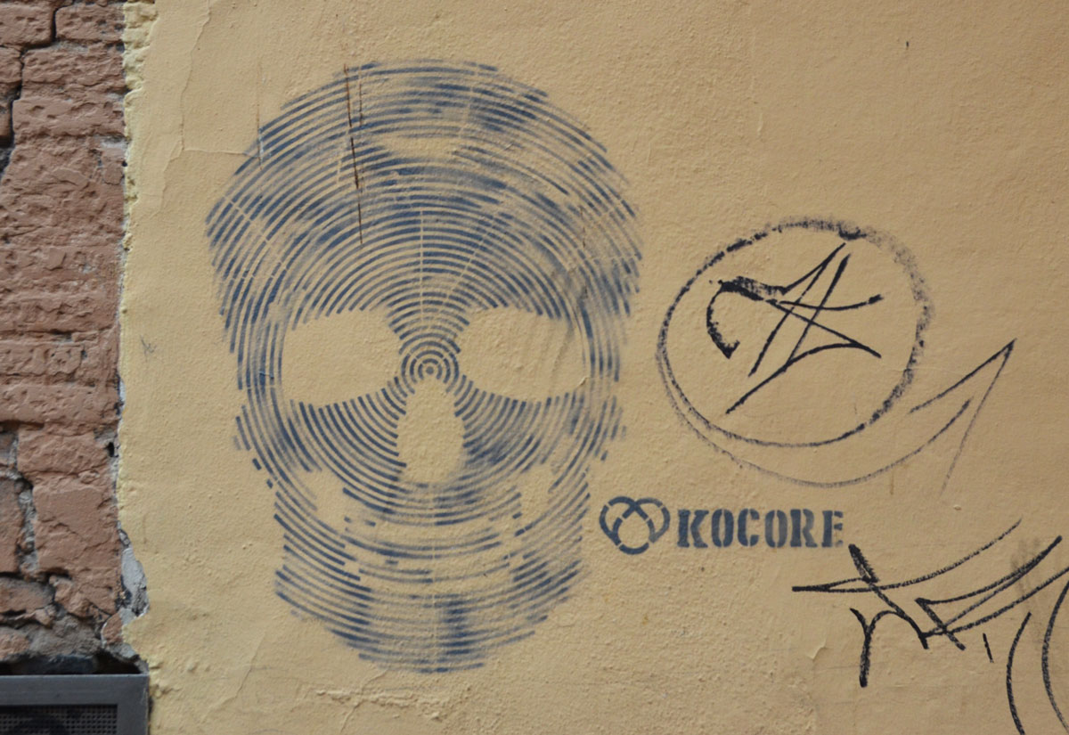 street art piece of a skull made up of lots of grey lines The word Kocore is beside the skull 