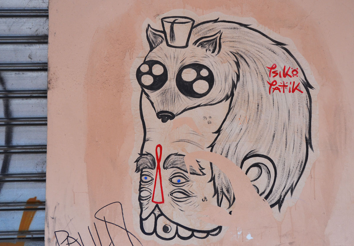 a grey tone graffiti on a pinkish wall, a small furry animal with a fez on its head and eyes that resemble nuclear symbols, sits atop a man's head. he has two sets of eyes and a large mouth with teeth