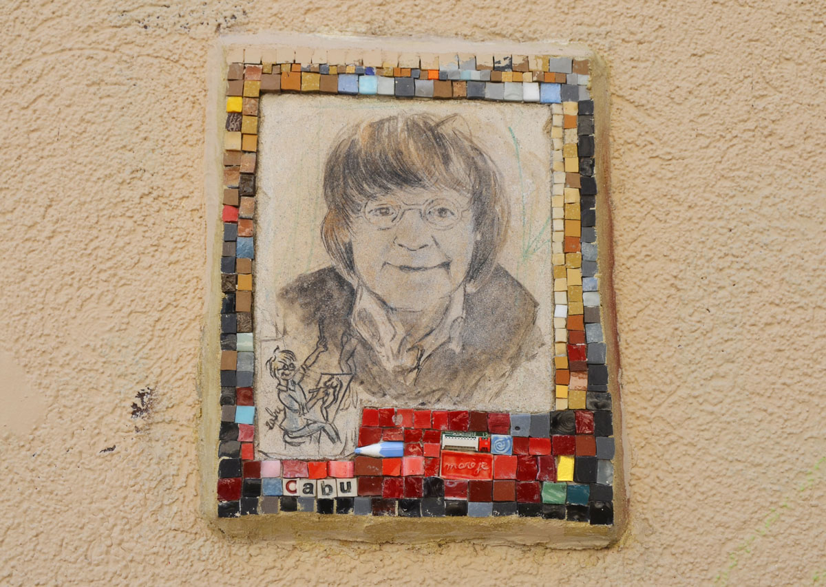 small portrait of a man on a wall.  Hand drawn head and shoulder shot, framed with tiny pieces of mosaic tile - Cabo