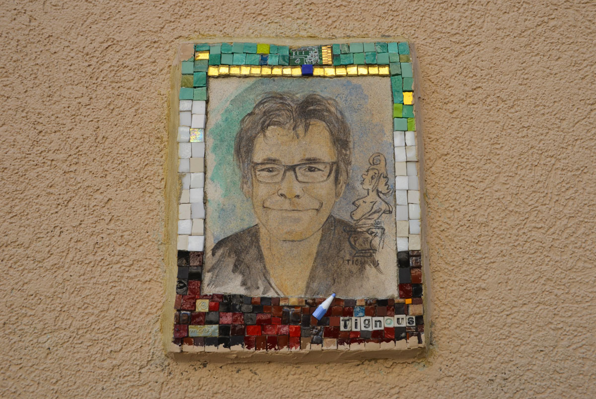 small portrait of a man on a wall.  Hand drawn head and shoulder shot, framed with tiny pieces of mosaic tile - Tingous