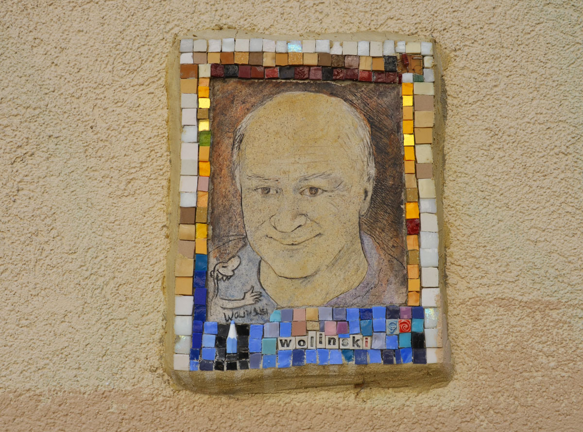 small portrait of a man on a wall.  Hand drawn head and shoulder shot, framed with tiny pieces of mosaic tile - Wollinski