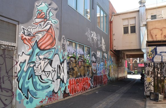 view of a lane with graffiti and street art on both sides