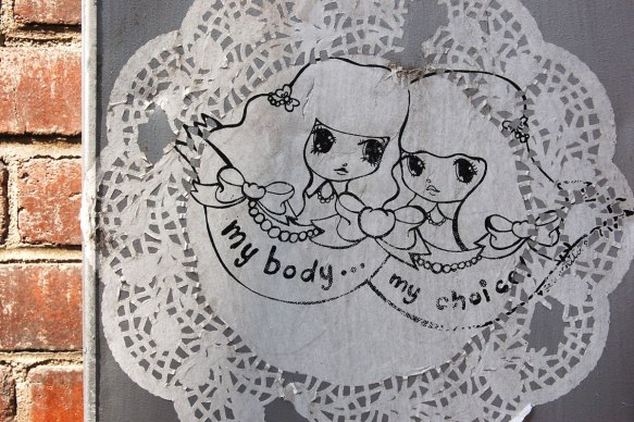 Starchild Stela character, a girl with shoulder length and slightly curly hair, two girls in the center of a doily, with the words 'my body, my choice'