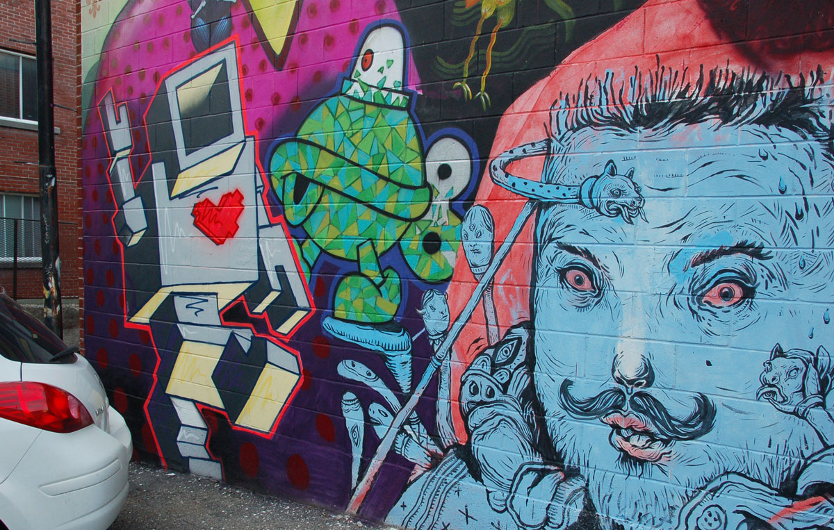 a large lovebot as part of a large painted mural on a wall.