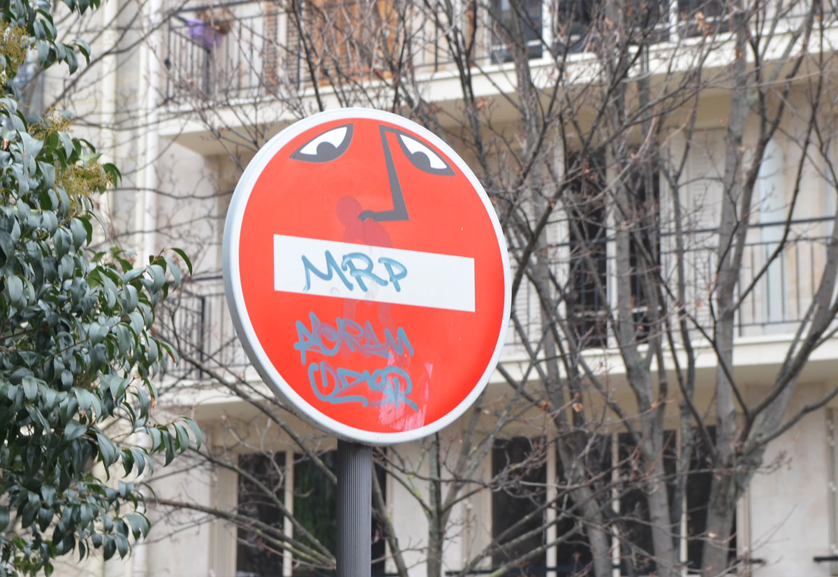 graffiti altered no entry sign, red circle with a white horizontal bar - added eyes and nose above the bar, bar now looks like a mouth