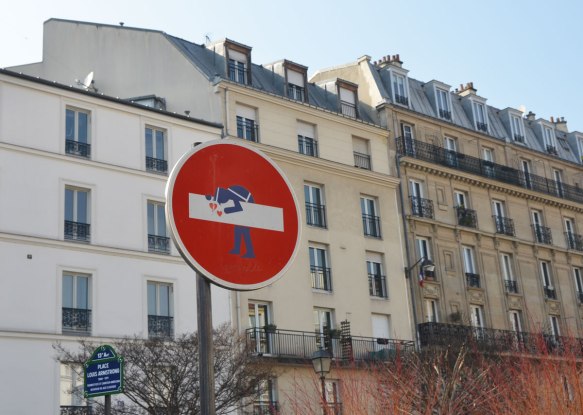 graffiti altered no entry sign, red circle with a white horizontal bar - added a policeman leaning over it, with hearts