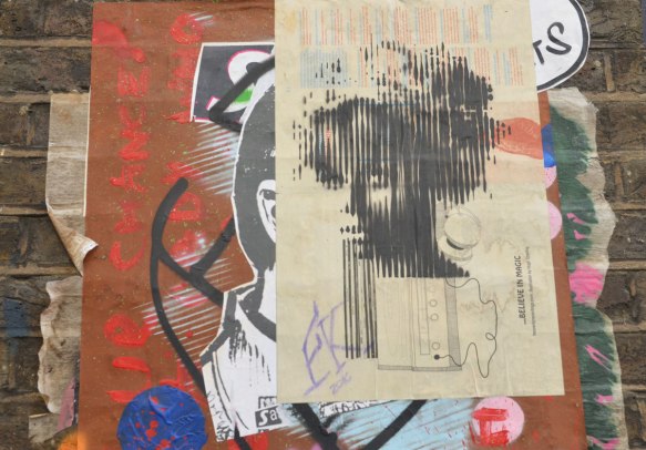 paste up graffiti of a woman's head with words 