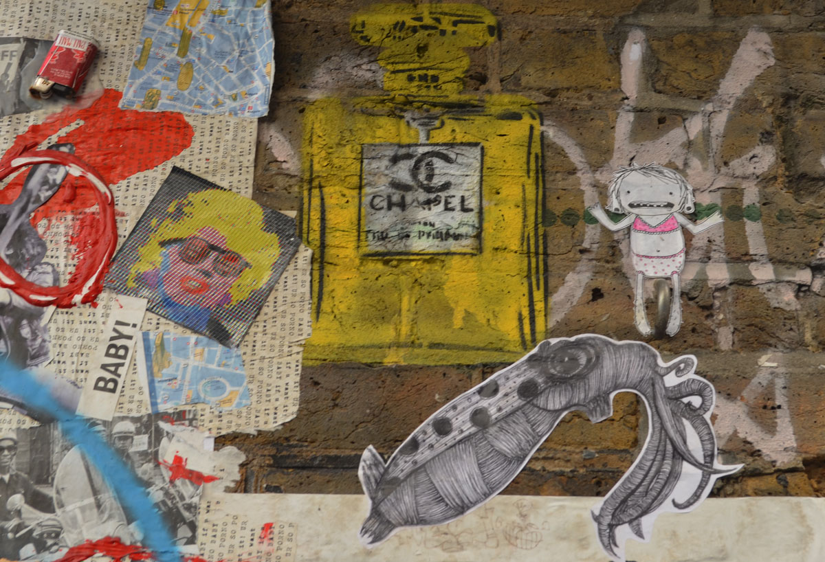 little bits of graffiti, marilyn munroe like sticker, a pasteup of a squid, a little girl in pink bra and panties, a yellow parody of a chanel perfume bottle