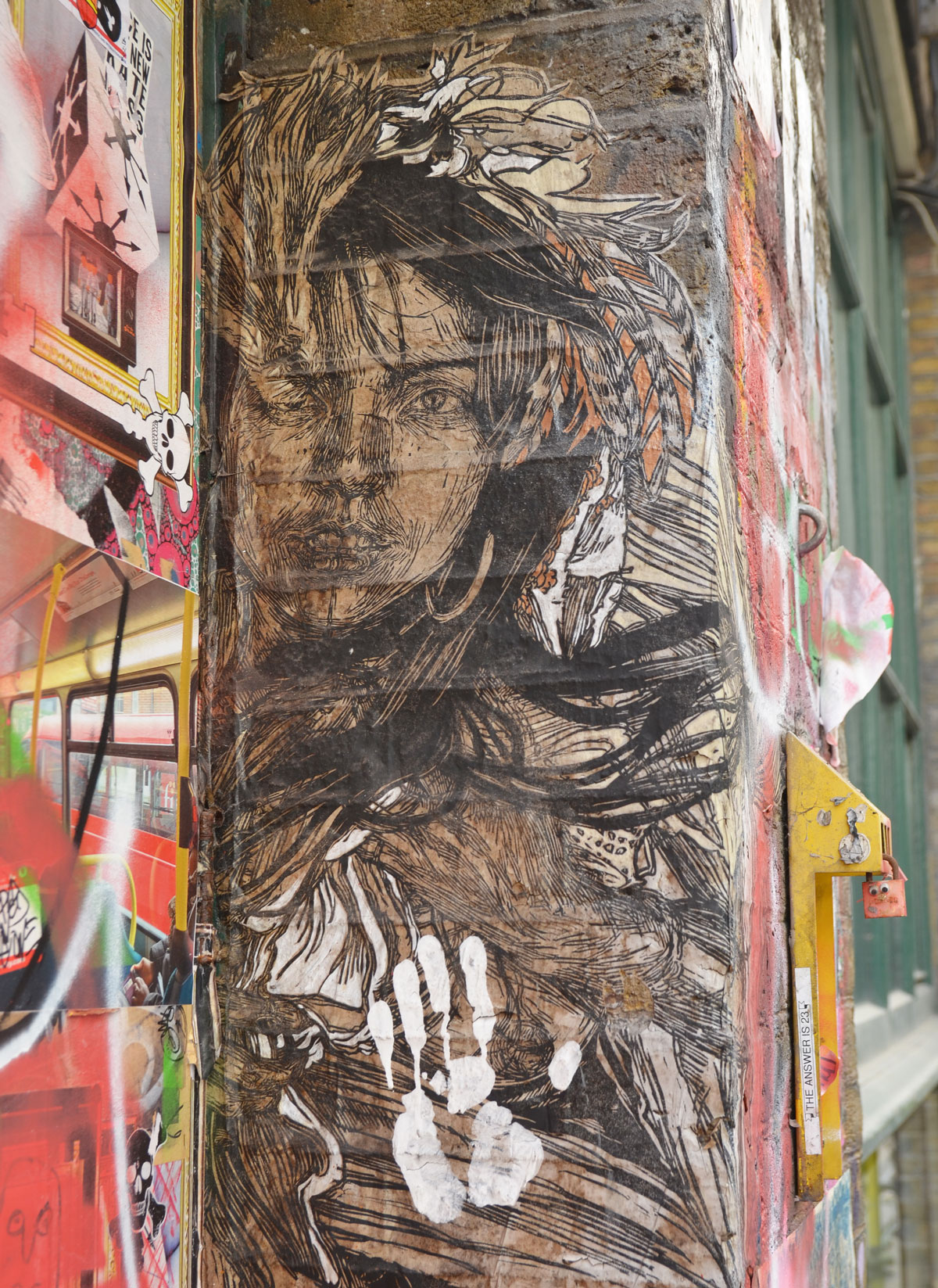 street art picture of a woman in browns and blacks, long hair, amongst other graffiti
