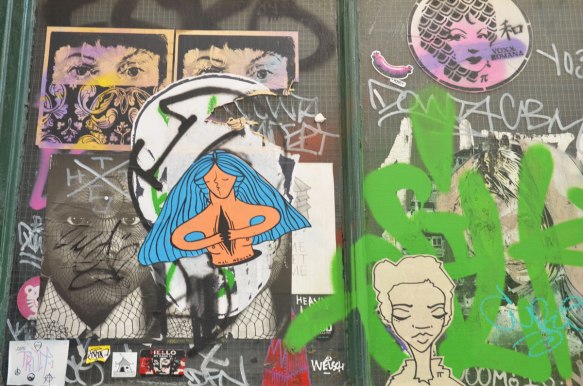 stickers and paste ups on a wall, faces, 