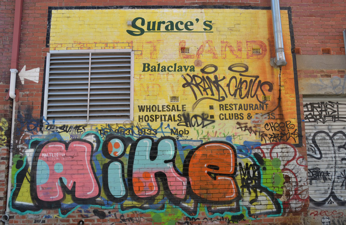 on the side of Surace's store in Balaclava Melbourne, a large graffiti text of the name Mike in fat letters