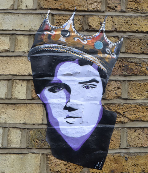 a paste up head of Elvis with a gold & jewel crown on his head 