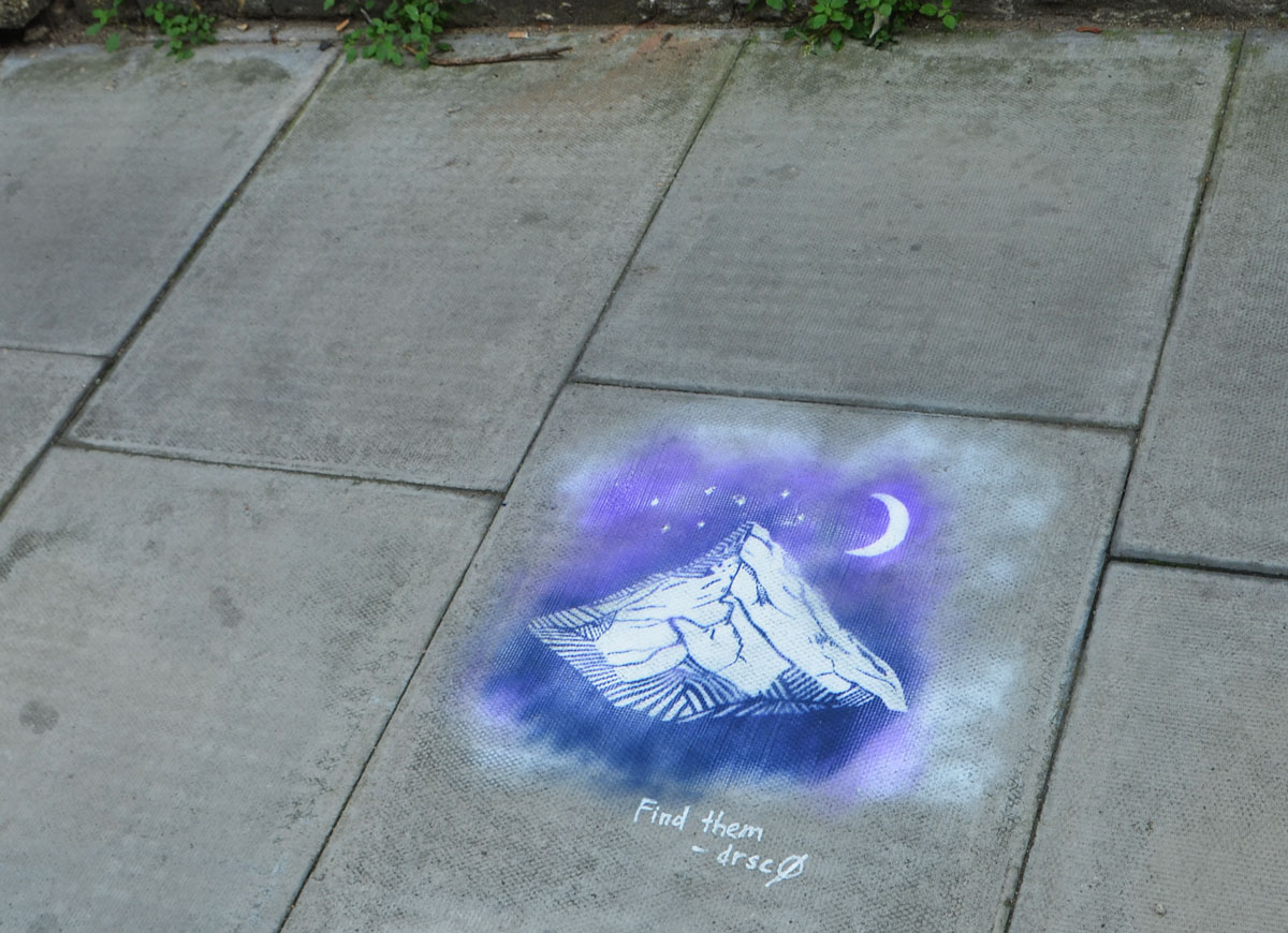 sidewalk stencil of mountain, moon and stars in white on blue and purple background, with words, find them, drsc0 '16