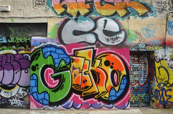 large colourful tag that says gecko on a wall with other tags 