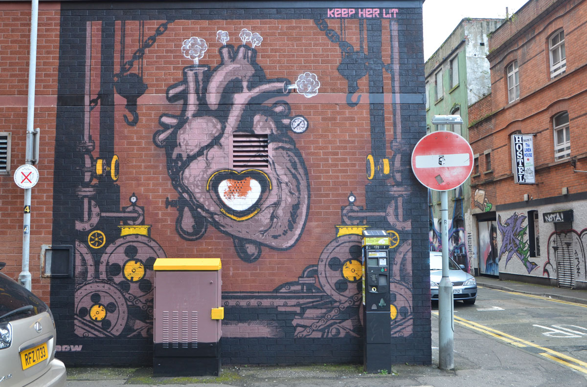 a mural of an anatomical painting of a heart with the center being a furnace, steam puffs coming out of the vessels at the top, words at the top of the mural are Keep Her Lit 