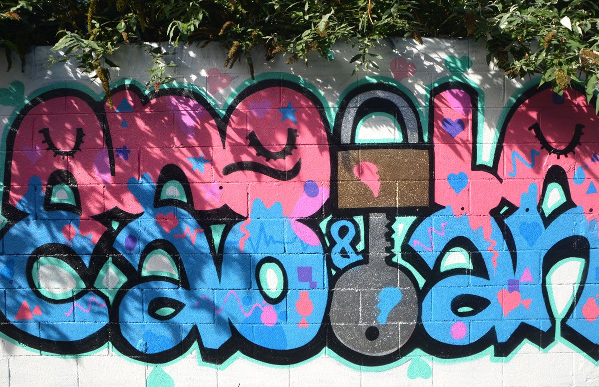 graffiti that says angela & caolan. Angela is in pink letters and caolan is in blue. the e in angela is a lock and the L in caolan is a key. The key fits into the lock. 