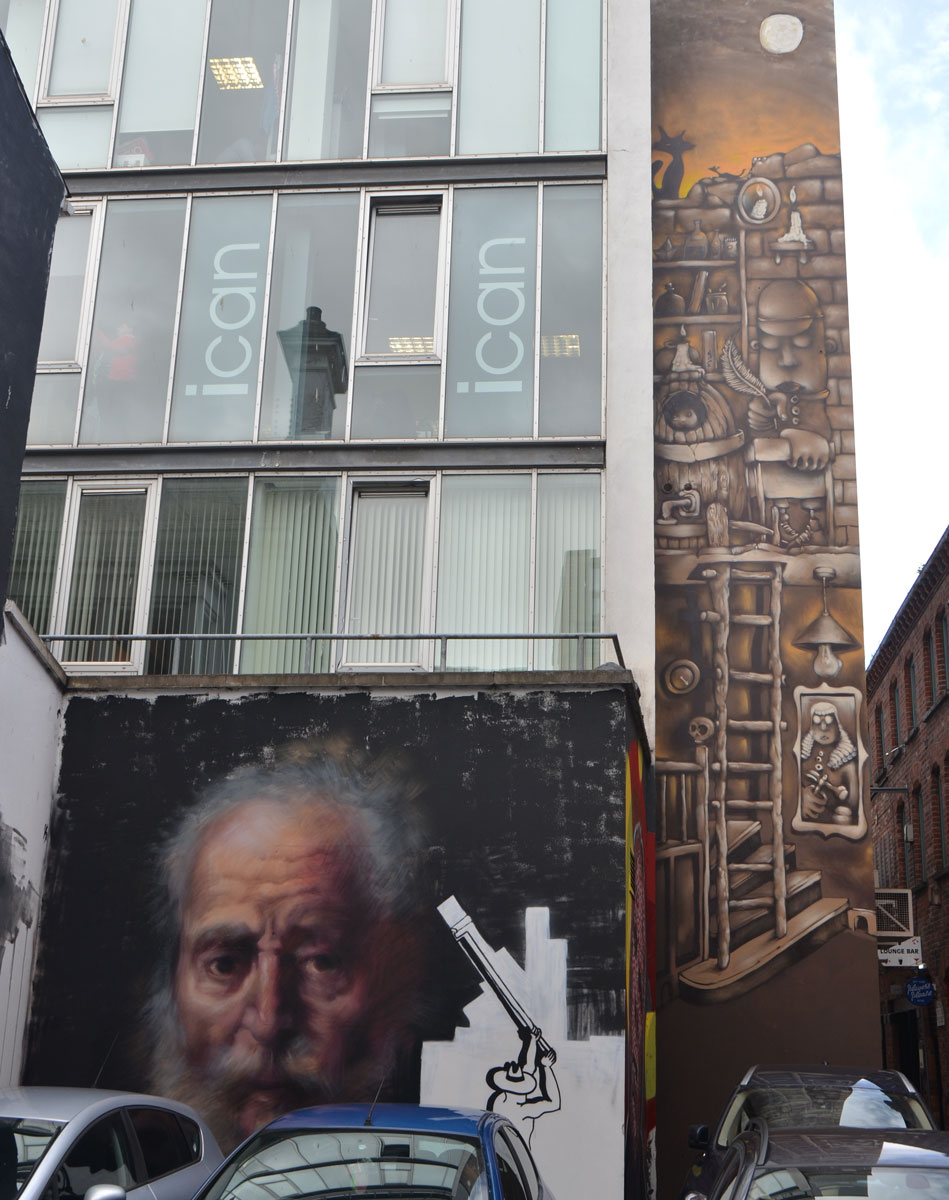 two murals on a building, one is a very realistic painting of an old man and the other is a vertical painting in brown tones by KVLR