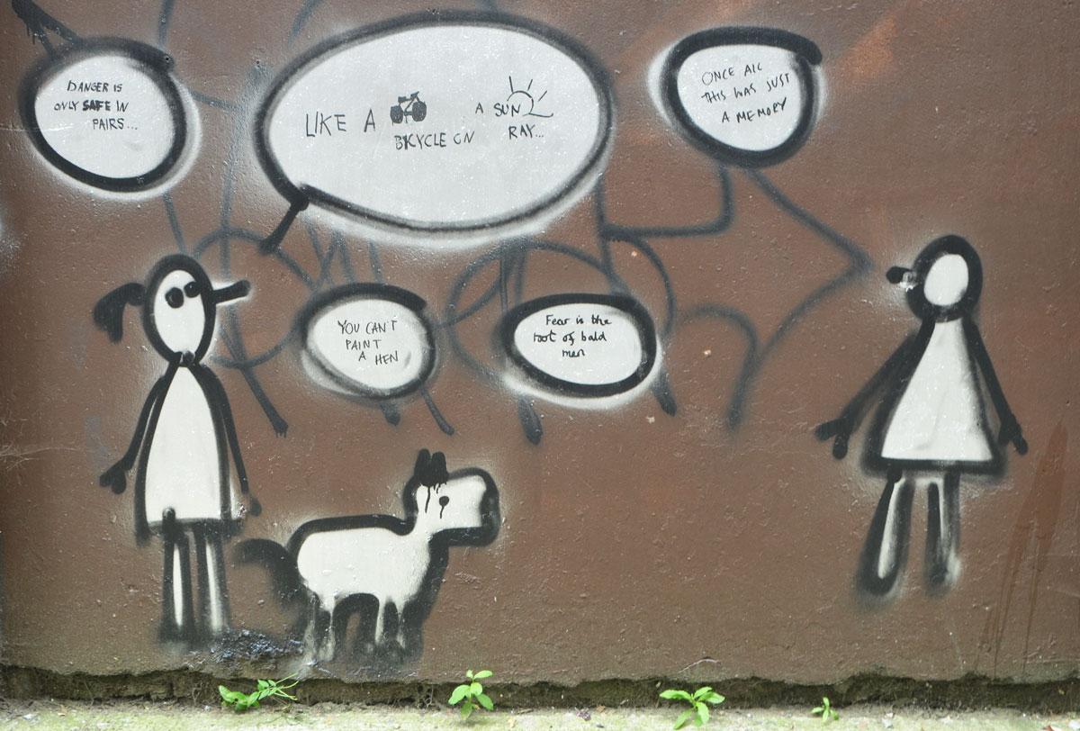 black outlined stick figures with white word bubbles, two people and a dog. 