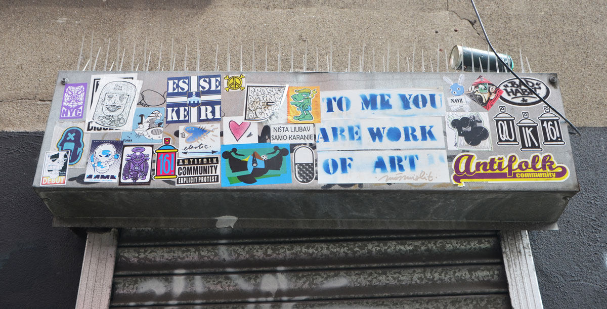 stickers across the top of a doorway, exterior, including one that says To me you are a work of art. 