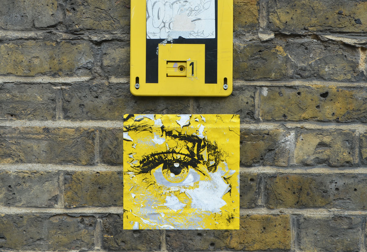 a small square paste up in yellow with black drawing of an eye