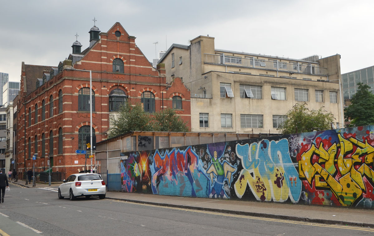 street art and graffiti in Shoreditch England, on Braithwaite Street, construction hoardings covered with street art 